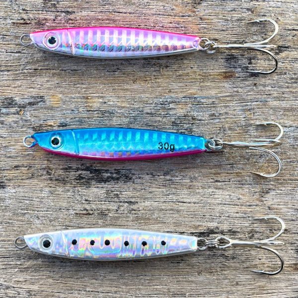 Photo of three SnapperTackle Kahawai Jigs displayed horizontally in order of Pink, Blue, and Silver